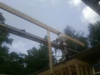 Carpenter setting a ridge beam over a new addition frame — Ice Dam Removal by Roofing Brothers in Markleville